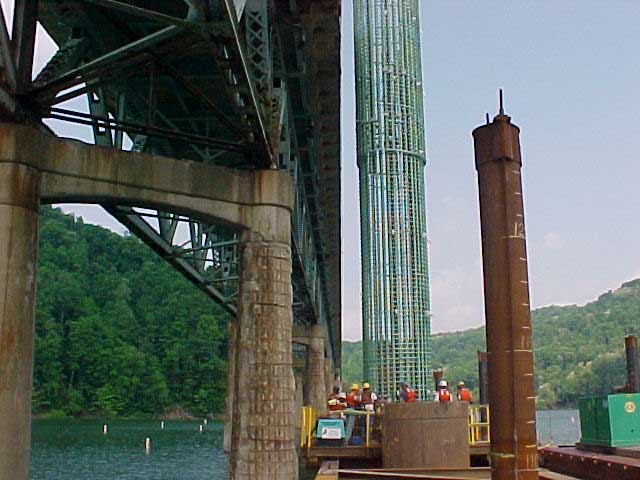 Putting steel reinfocing cage with CSC guide wheels in steel casing Rebar cage
